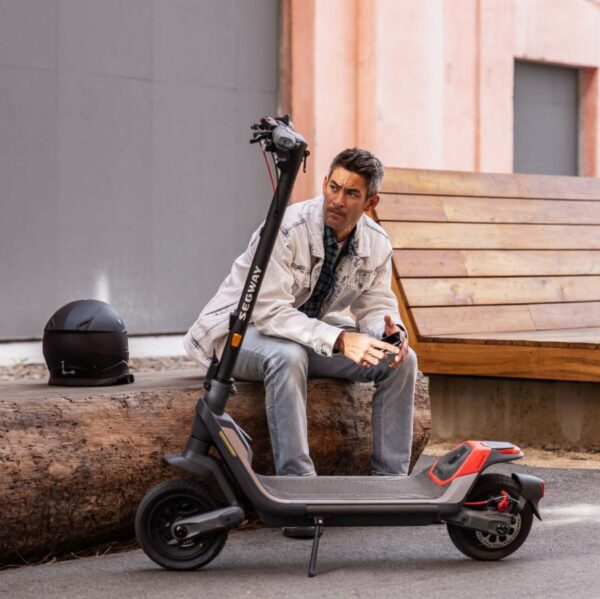Un homme avec son casque assis devant sa trottinette électrique Segway P100SE