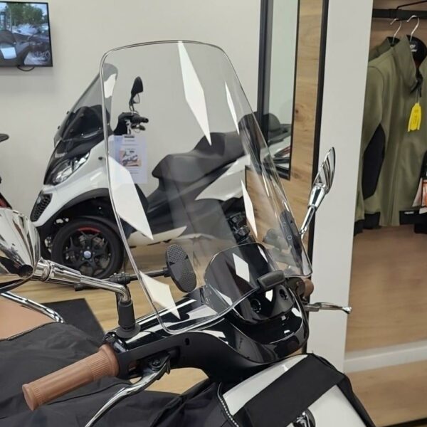 On voit la bulle saute vent en version haute de la marque PUIG montée sur un scooter électrique Segway blanc