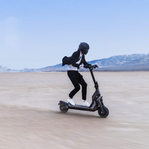 Segway KickScooter GT2 trottinette électrique roule dans un désert avec un homme qui as un casque intégrale sportif