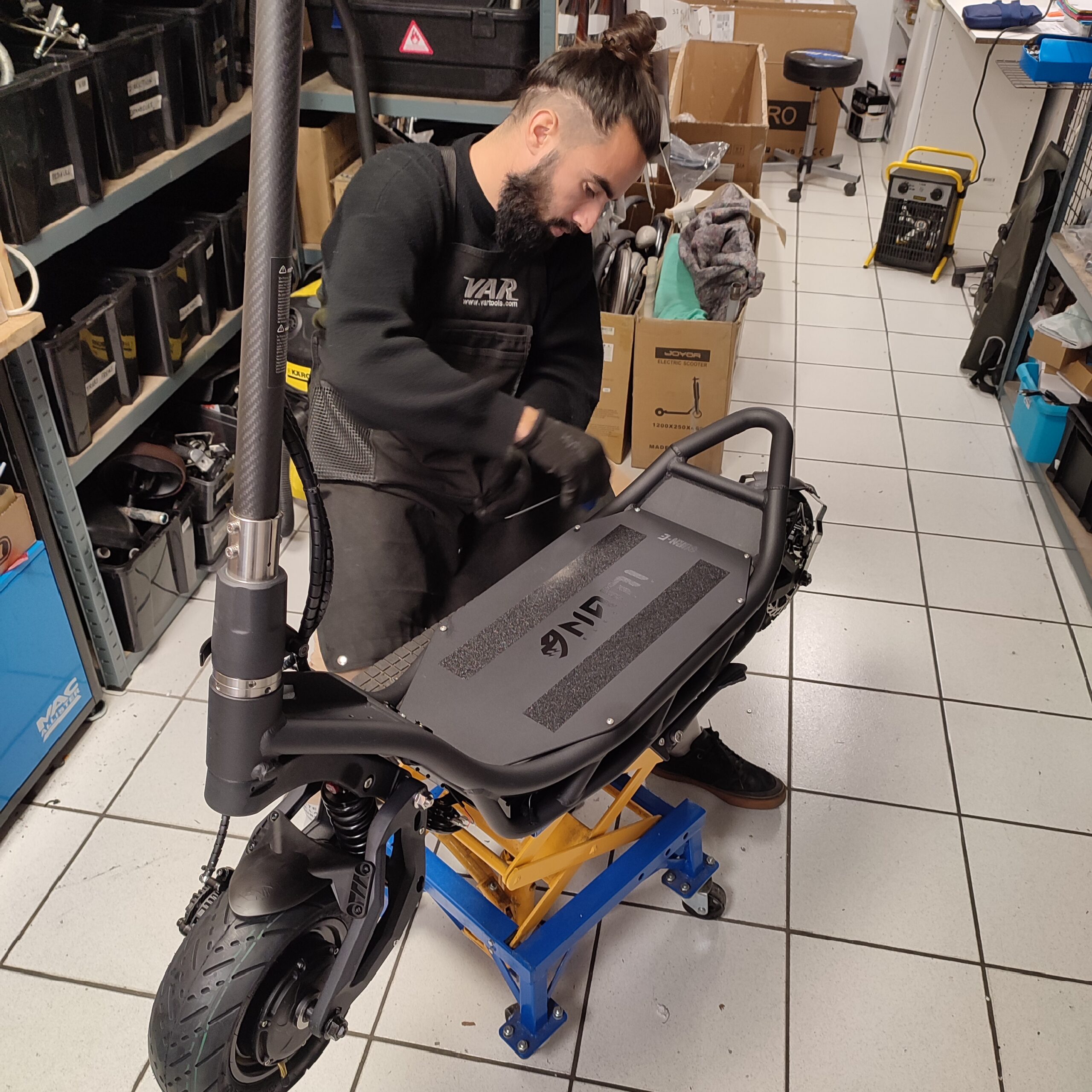 un employé du magasin Cittytrott procède à la maintenance d'une trottinette électrique;